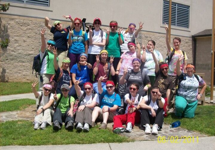 Group of summer camp staff pose outdoors for a picture dressed in hiking apparel.